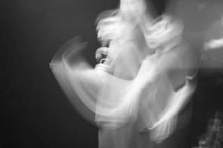 Abstract blurred figures in motion against dark background