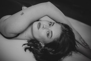A black and white portrait of a woman lying down.