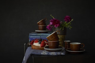a table topped with books and cups filled with food
