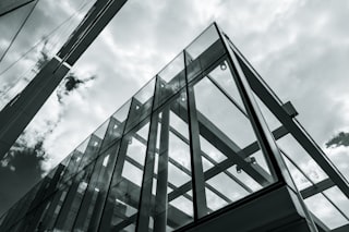 Modern glass building against cloudy sky