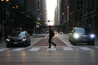 Man crosses a city street at a crosswalk.