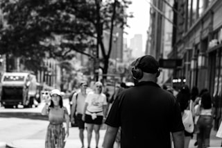 Man with headphones walks down city street